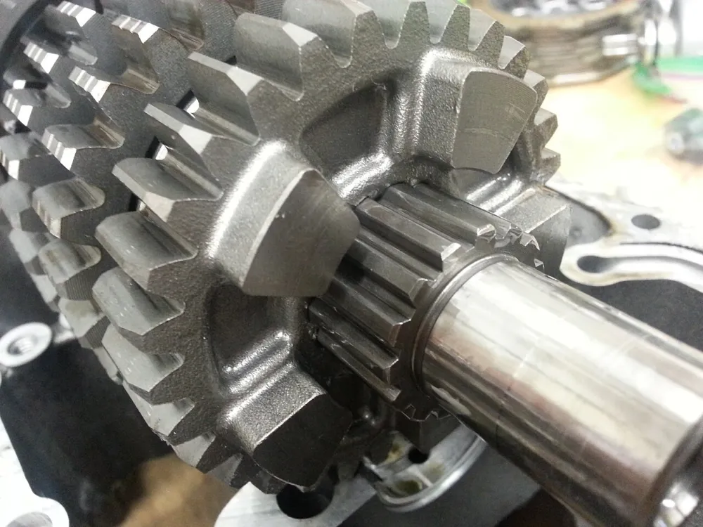 Close-up of motorcycle gearbox gears with square dog lugs on the face of the gear
